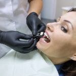 Adult female dentist choosing tooth implant. Medicine, dentistry and healthcare concept
