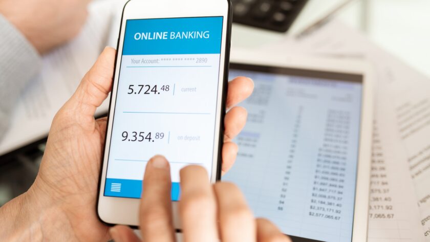 Hands of businessperson with smartphone scrolling through online banking account